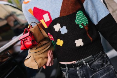 Milan, İtalya - 25 Eylül 2025: Moschino Tie Me çantası giyen adam. Moda kıyafeti çanta ayrıntıları, sokak tarzı aksesuar.