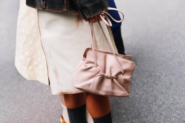 Milan, İtalya - 25 Eylül 2025: Kadın açık pembe Prada Dada çanta giyiyor. Moda kıyafeti çanta ayrıntıları, sokak tarzı aksesuar.