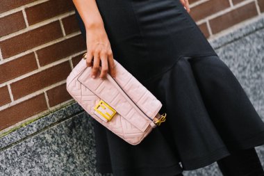 Milan, İtalya - 24 Eylül 2025: Kadın Fendi Baguette pembe çanta giyiyor. Moda kıyafeti çanta ayrıntıları, sokak tarzı aksesuar.