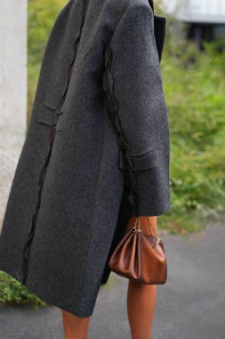 Milan, İtalya - 25 Eylül 2025: Kadın kahverengi Prada Tumulte nappa deri çanta giyiyor. Moda kıyafeti çanta ayrıntıları, sokak tarzı aksesuar.