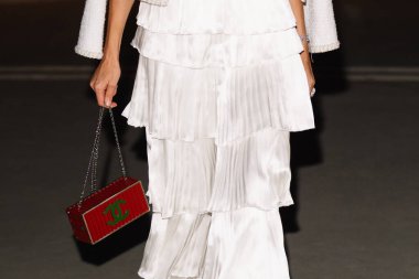 Paris, Fransa - Ekim 06, 2025: Kadınlar Chanel konteyner debriyaj çantası takarlar. Moda kıyafeti çanta ayrıntıları, sokak tarzı aksesuar.