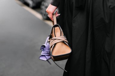 Milan, İtalya - 25 Eylül 2025: Kadınlar Moschino Tie Me çantası takıyor. Moda kıyafeti çanta ayrıntıları, sokak tarzı aksesuar.