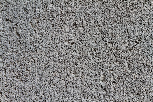 Close up of a coarse, dark gray concrete wall — Stock Photo, Image