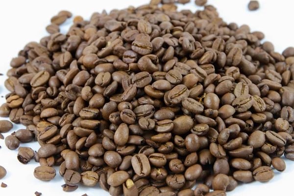 Close up de uma pilha de grãos de café em um fundo branco — Fotografia de Stock