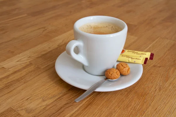 View of a coffee cup with sugar sachets and biscuits — Stock Photo, Image