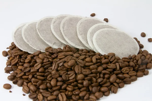 Coffeepads een stapel van koffie bonen Stockfoto