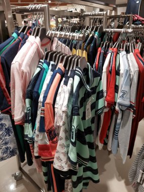 Satılık bir alışveriş merkezinde sergilenen birkaç yeni gelen ve renkli tişört koleksiyonu