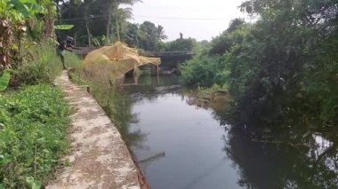 Kottayam, Kerala Hindistan 7 Nisan 2021 balıkçı, Kerala Hindistan 'dan yavaş bir motin ile bir nehre ağ atıyor.