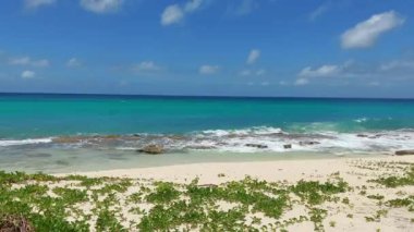 Dalgalar Philipsburg St. Maarten 'deki kayalık bir sahile çarpıyor.