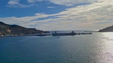 İspanya Murcia Jan 42024 Liman Manzarası Limanlı Gemiler, Sakin Deniz ve Rocky Hills üzerinde Parlak Mavi Gökyüzü