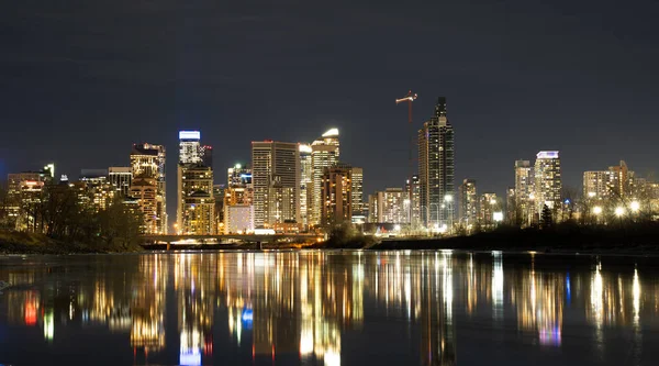 stock image Downtown Calgary office building lights reflecting on the Bow River at night.