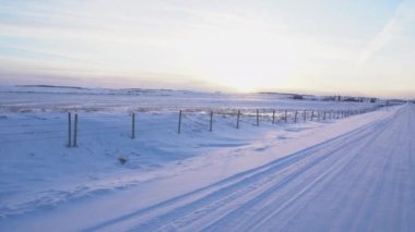 Rocky View County Alberta Kanada 'da karla kaplı tarım arazileri olan dikenli teller boyunca uçun..
