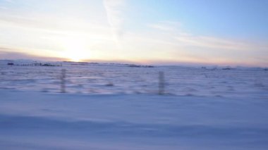 Rocky View County Alberta Canada 'da karla kaplı tarım arazileri olan dikenli tel çitlerin yanından geçen çayır..
