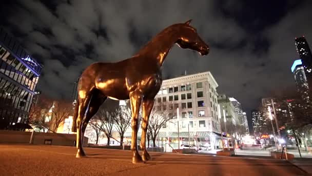 カルガリーアルバータ州カナダ 2021年3月15日 夜間にダウンタウンの建物の背景を持つ馬の彫刻の広い角度追跡運動 — ストック動画