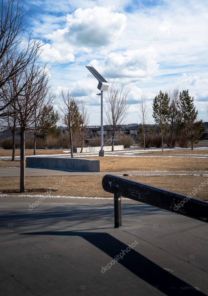 A solar powered lamp post recharging in the sun at a public community skateboard park in Airdrie Alberta Canada.