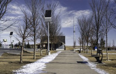 Airdrie Alberta Kanada 'daki sürdürülebilir bir halk parkında sokak lambalarını şarj eden güneş panelleri.