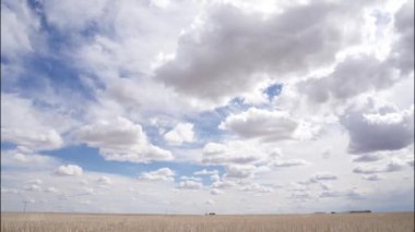Prairie time lapse of clouds racing over a farm field on the Canadian prairies in Rocky View County Alberta.