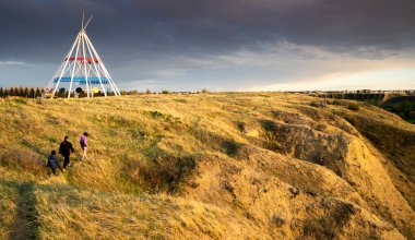 Medicine Hat Alberta Canada, 13 Mayıs 2021: Bir aile gün batımında Sammis Çadırı 'nın yanındaki Seven Persons Coulee' de yürüyüş parkurunda yürür..