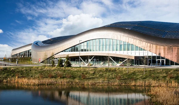 Calgary Alberta Canada, May 12 2021: The Rocky Ridge YMCA sport facility reflecting on a natural habitat area under a cloudy sky in a Canadian city.