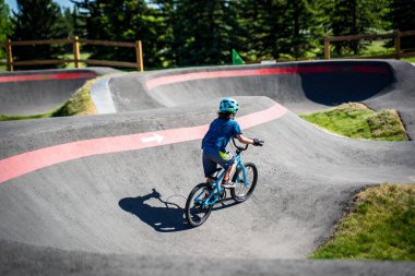 Bir yaz akşamı Calgary Alberta Kanada 'da yeni South Glenmore Park BMX pompa pistine binen genç bir çocuk görülüyor..