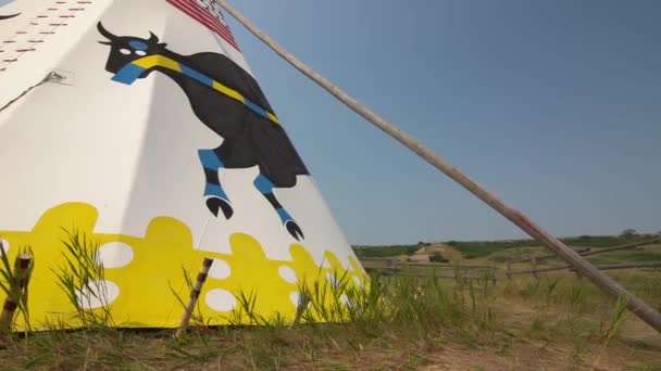 アルバータ州 カナダ 2021年7月30日 バッファロージャンプのヘッドスマッシュのベースに飾られた伝統的な先住民のティーピースタンドのパンニング運動 — ストック動画