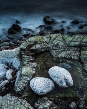 Şafak vakti kıyı koyundaki kayaların görüntüsü