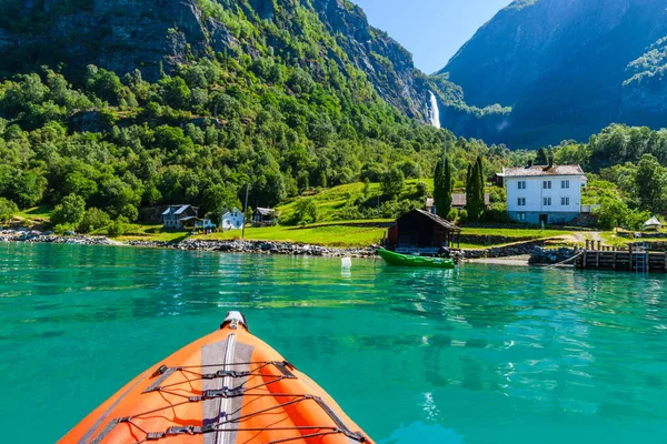 Norveç manzarasının önündeki kırmızı şişme kano.