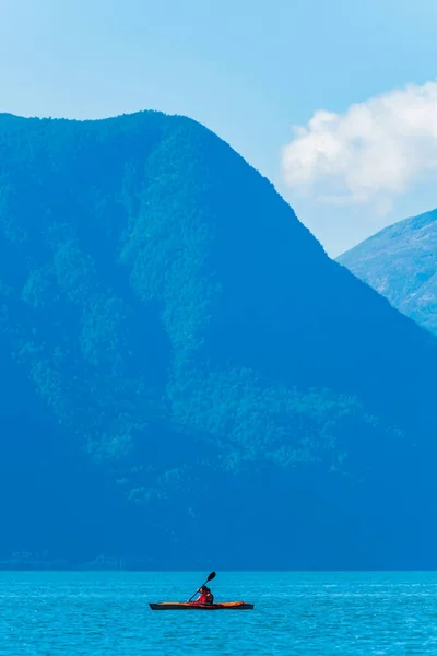 Norveç manzarasının önündeki kırmızı şişme kano.