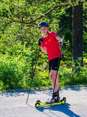 IDRE, SWEDEN - JUNE 20, 2020: Boy with roller skis clipart