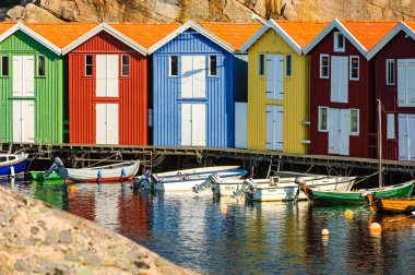 Renkli sahil kulübeleri ve denize demirlemiş tekneler.