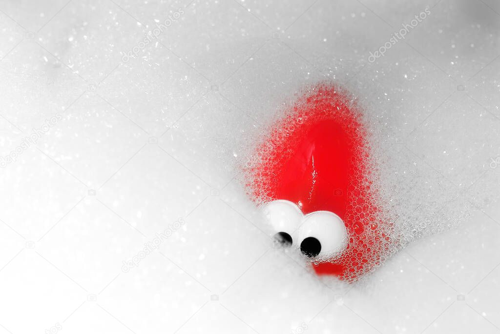 Red toy in the bathroom surrounded by bubbles