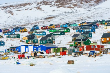 Bu sahnede Grönland 'ın Qaanaqq köyündeki renkli binalar gösteriliyor. Köy, karlı bir manzarada ev ve yapıların bir karışımına sahip ve yerel yaşamı ve çevreyi ön plana çıkarıyor..
