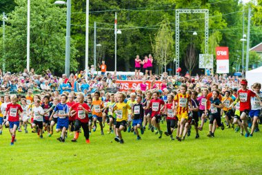 Göteborg 'daki Lilla Varvet yarışına çocuklar katılıyor. Birçok çocuk yeşil bir alanda koşarken yetişkinler kenardan izliyor ve etkinlik sırasında canlı bir atmosfer yaratıyor..
