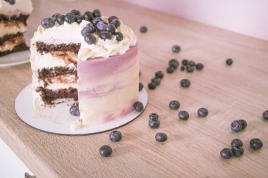 Dilimlenmiş sünger kek ve ahşap bir masada yaban mersini.