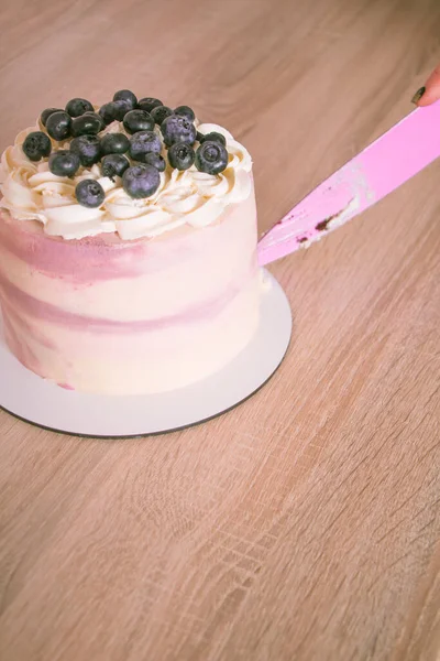 ピンクのナイフで木製のテーブルの上にブルーベリーとスライススポンジケーキ — ストック写真
