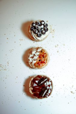 Beyaz arka planda kremalı ve dolgulu farklı tipte kekler.