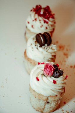 Beyaz arka planda kremalı ve dolgulu farklı tipte kekler.