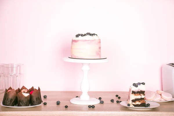 ブルーベリーと木製のテーブルの上に別のデザートとケーキをスポンジ — ストック写真