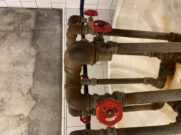 Old pipes with red handles in the building