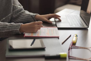 Genç kız evde ders çalışıyor.