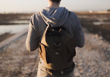 Sırt çantası ve gün batımı olan bir adam.