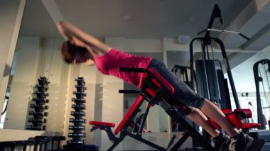 Genç kadının geri jimnastik salonu için egzersiz yapması