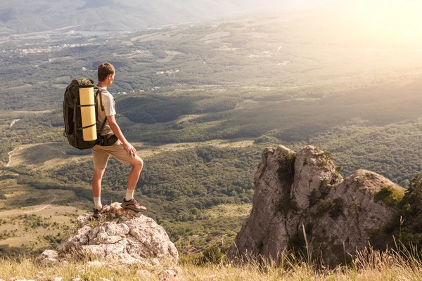 Mochilero en la roca y mirando el gran valle —  Fotos de Stock