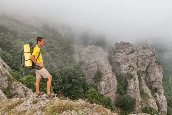 Wandelaar met backpacker in de mistige bergen — Stockfoto