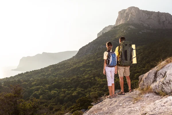 Couple regardant le lever du soleil depuis la montagne — Photo