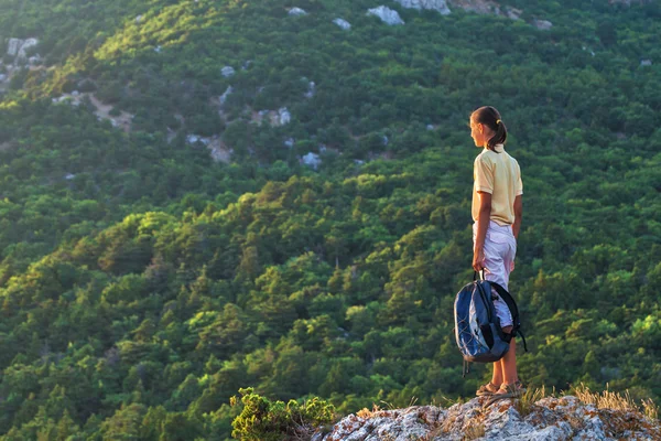 Sırt çantası bir kaya üzerinde olan kadın