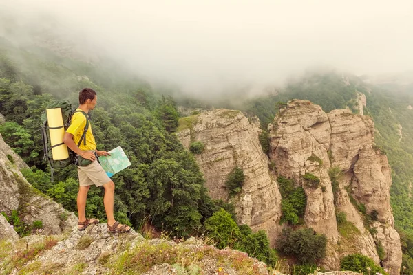 Backpacker met een kaart op de bergen — Stockfoto