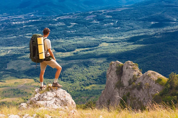 Backpacker staat op rock en kijken naar vallei — Stockfoto