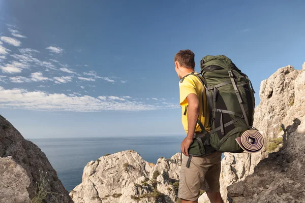 Homme avec sac à dos sur roche haute — Photo