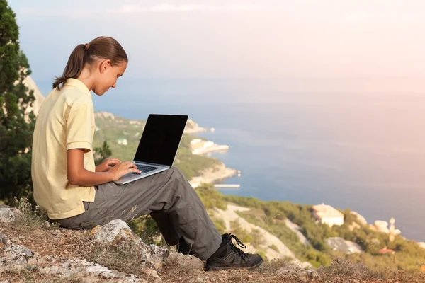 Chica trabajando con el ordenador portátil en la montaña — Foto de Stock